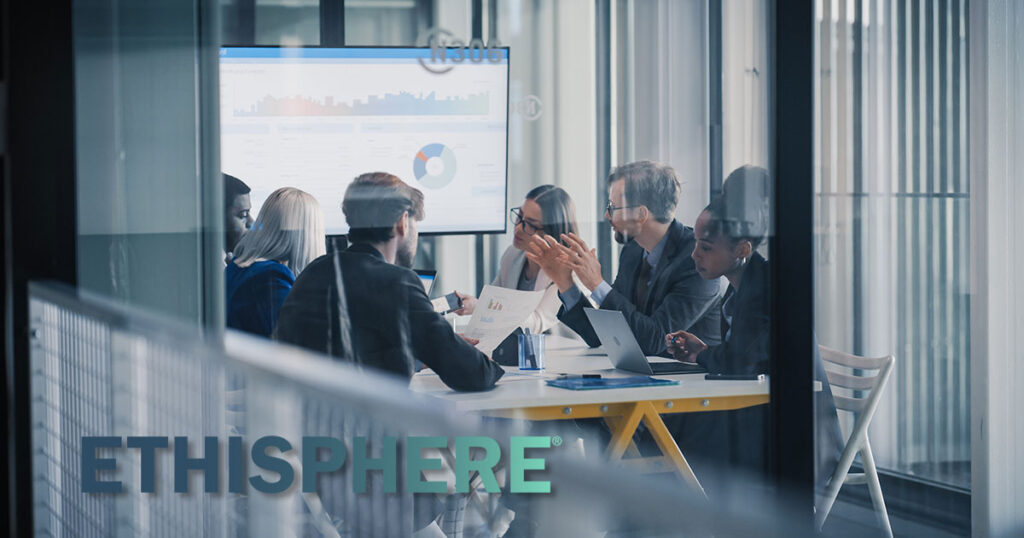 Business Leaders Sit Around a Conference Table Reviewing Charts on a Large Screen