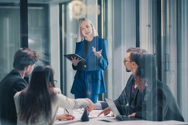 Businesswoman Leads a Strategy Meeting in a Glass Office